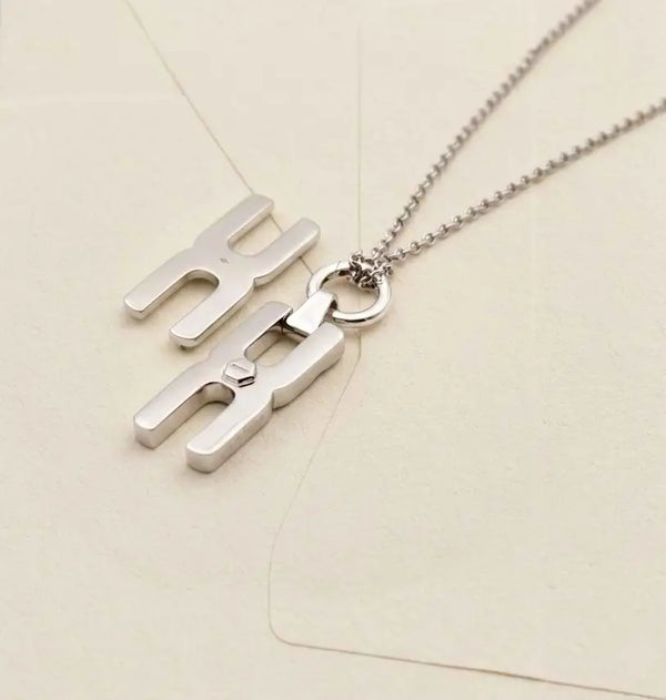 Détail du pendentif Hera S en argent rhodié avec maille forçat élégante, création artisanale Alhiage pour mèche de cheveux