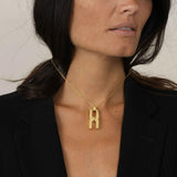 Femme portant le collier Hera T en or vermeil, bijou personnalisé à compartiment pour mèche de cheveux, symbole d'amour et de connexion