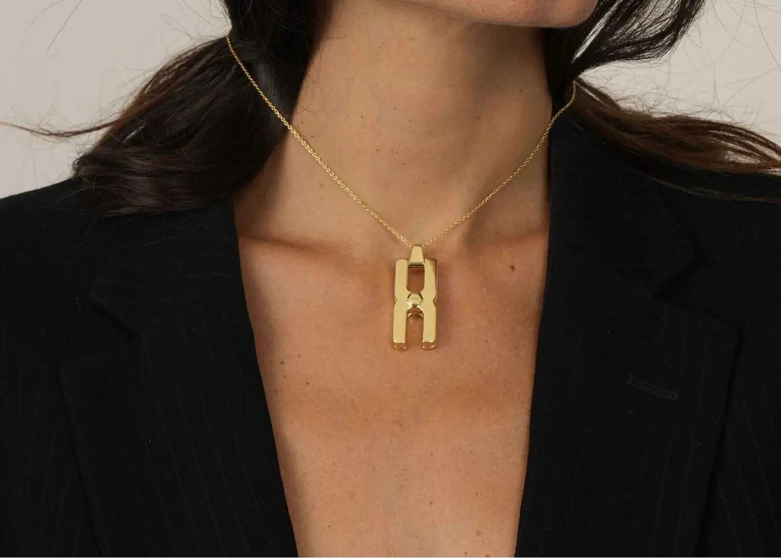 Femme portant le collier Hera T en or vermeil, bijou personnalisé à compartiment pour mèche de cheveux, symbole d'amour et de connexion