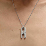 Gros plan du fermoir et de la chaîne maille forçat du pendentif Hera R en argent rhodié, finition artisanale française Alhiage